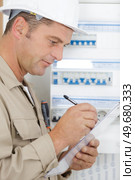 electromechanic next to distribution fuseboard. Стоковое фото, агентство Ingram Publishing / Фотобанк Лори