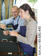 senior shoemaker training apprentice to work with leather. Стоковое фото, агентство Ingram Publishing / Фотобанк Лори