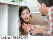 woman looking at male plumber cleaning clogged pipes. Стоковое фото, агентство Ingram Publishing / Фотобанк Лори