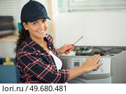 female plumber fixing a washing machine. Стоковое фото, агентство Ingram Publishing / Фотобанк Лори