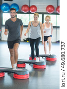 group working out with dumbbells and steppers in gym. Стоковое фото, агентство Ingram Publishing / Фотобанк Лори