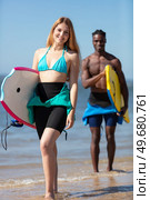 couple of body boarders walking towards sea. Стоковое фото, агентство Ingram Publishing / Фотобанк Лори