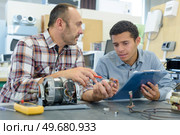 mechanic showing engines to apprentices low angle. Стоковое фото, агентство Ingram Publishing / Фотобанк Лори