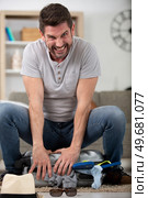 angry man tries to close his suitcase. Стоковое фото, агентство Ingram Publishing / Фотобанк Лори