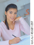 happy girl in casual clothes writing at desk. Стоковое фото, агентство Ingram Publishing / Фотобанк Лори