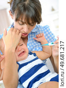 a crying baby with her mum. Стоковое фото, агентство Ingram Publishing / Фотобанк Лори