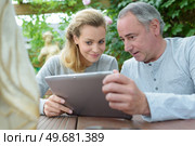 couple looking at photos on tablet. Стоковое фото, агентство Ingram Publishing / Фотобанк Лори