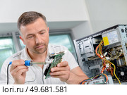 man is soldering computer component. Стоковое фото, агентство Ingram Publishing / Фотобанк Лори
