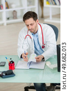 doctor talking checking his agenda in the office. Стоковое фото, агентство Ingram Publishing / Фотобанк Лори