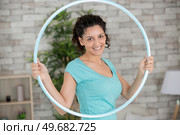 young woman exercising with hula hoop. Стоковое фото, агентство Ingram Publishing / Фотобанк Лори