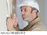 professional male stripping wallpaper with a scraper. Стоковое фото, агентство Ingram Publishing / Фотобанк Лори