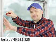 worker fasten the handle to a plastic window. Стоковое фото, агентство Ingram Publishing / Фотобанк Лори