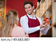 sommelier in wine store giving woman recommendation. Стоковое фото, агентство Ingram Publishing / Фотобанк Лори