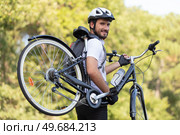 male cyclist carrying his bicycle. Стоковое фото, агентство Ingram Publishing / Фотобанк Лори