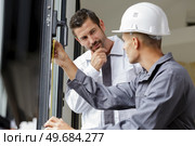a man measuring double glazing door. Стоковое фото, агентство Ingram Publishing / Фотобанк Лори