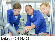 engineer showing apprentices how to operate machine. Стоковое фото, агентство Ingram Publishing / Фотобанк Лори