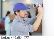 contractor installing a discreet security camera in a hospital. Стоковое фото, агентство Ingram Publishing / Фотобанк Лори