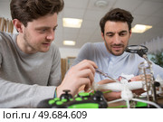 medium shot of a father and son repairing a drone. Стоковое фото, агентство Ingram Publishing / Фотобанк Лори