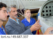 People looking at aircraft parts. Стоковое фото, агентство Ingram Publishing / Фотобанк Лори