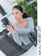 a female photographer checking camera. Стоковое фото, агентство Ingram Publishing / Фотобанк Лори