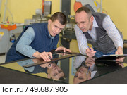 two careful workmen work at pvc windows factory. Стоковое фото, агентство Ingram Publishing / Фотобанк Лори