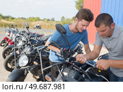 men at motorcycle salon oustide. Стоковое фото, агентство Ingram Publishing / Фотобанк Лори