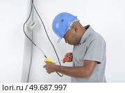 an electrician wiring up switch. Стоковое фото, агентство Ingram Publishing / Фотобанк Лори