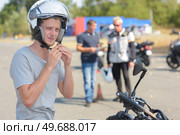 portrait of man putting his helmet. Стоковое фото, агентство Ingram Publishing / Фотобанк Лори
