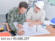 Two men looking at blueprints. Стоковое фото, агентство Ingram Publishing / Фотобанк Лори