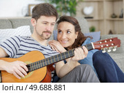 woman proudly watching her partner play the guitar. Стоковое фото, агентство Ingram Publishing / Фотобанк Лори