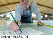 senior shipbuilder making his blueprint. Стоковое фото, агентство Ingram Publishing / Фотобанк Лори