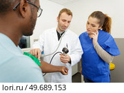 doctor and nurse with patient measuring blood pressure. Стоковое фото, агентство Ingram Publishing / Фотобанк Лори