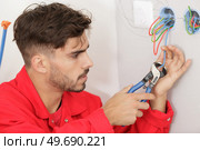 electrician trimming wire with cable cutters. Стоковое фото, агентство Ingram Publishing / Фотобанк Лори