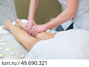 professional beautician massaging legs of female customer. Стоковое фото, агентство Ingram Publishing / Фотобанк Лори