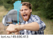 man trying to get rid of annoying insects. Стоковое фото, агентство Ingram Publishing / Фотобанк Лори