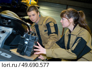 mechanics changing battery of jetski in garage. Стоковое фото, агентство Ingram Publishing / Фотобанк Лори