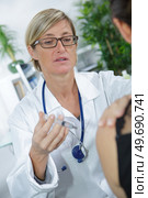 middle-age female doctor injecting vaccine isolated on white. Стоковое фото, агентство Ingram Publishing / Фотобанк Лори