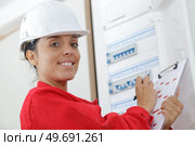 happy female builder inspecting fuse board. Стоковое фото, агентство Ingram Publishing / Фотобанк Лори
