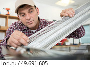 professional electrician fixing a heater. Стоковое фото, агентство Ingram Publishing / Фотобанк Лори