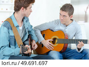 men are playing the guitar together. Стоковое фото, агентство Ingram Publishing / Фотобанк Лори