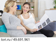 two pregnant young women talking about xrays. Стоковое фото, агентство Ingram Publishing / Фотобанк Лори