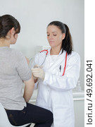 teen girl complaining to mature doctor about symptoms of malaise. Стоковое фото, агентство Ingram Publishing / Фотобанк Лори