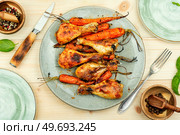 Tasty chicken legs baked with carrots on plate.. Roasted chicken drumstick with carrots. Стоковое фото, агентство Ingram Publishing / Фотобанк Лори