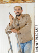 builder talking on portable uhf radio transceiver. Стоковое фото, агентство Ingram Publishing / Фотобанк Лори
