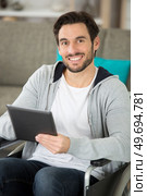 casually-dressed man in a wheelchair using a tablet. Стоковое фото, агентство Ingram Publishing / Фотобанк Лори