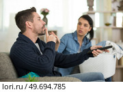man hushing wife while watching television. Стоковое фото, агентство Ingram Publishing / Фотобанк Лори