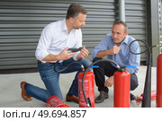 men are examining fire extinguishers. Стоковое фото, агентство Ingram Publishing / Фотобанк Лори