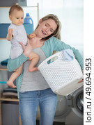 tearful woman holding baby washing and smartphone. Стоковое фото, агентство Ingram Publishing / Фотобанк Лори