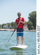 man enjoying a ride on the lake with paddleboard. Стоковое фото, агентство Ingram Publishing / Фотобанк Лори
