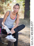 fitness woman suffering painful ankle sprain injury after running. Стоковое фото, агентство Ingram Publishing / Фотобанк Лори